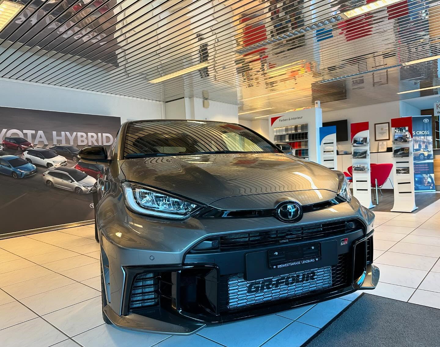 Grauer Toyota GR im Autohaus-Showroom, frontal präsentiert