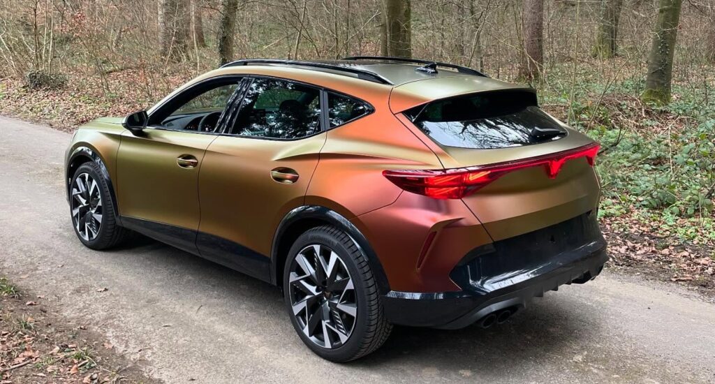 Sportlicher Crossover mit Farbwechsel-Folierung und getönten hinteren Scheiben, auf einem Waldweg geparkt.