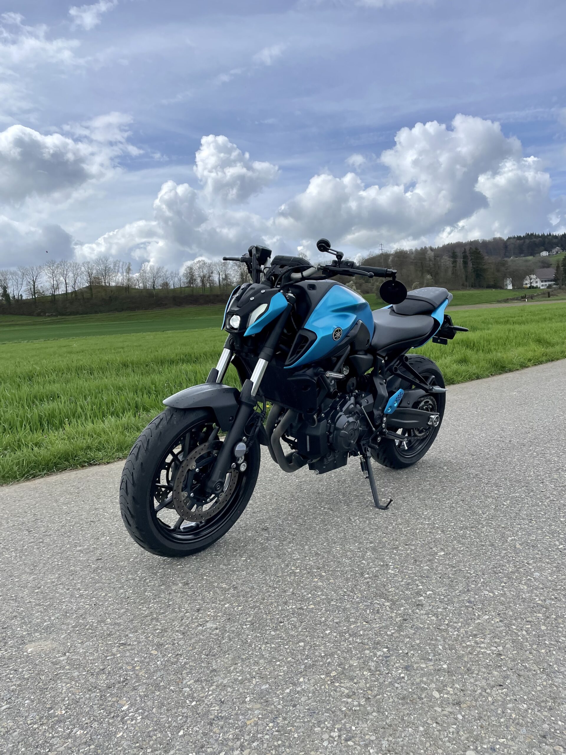 Vollfoliertes Motorrad als Referenzprojekt, fotografiert auf einer Strasse beim Wald