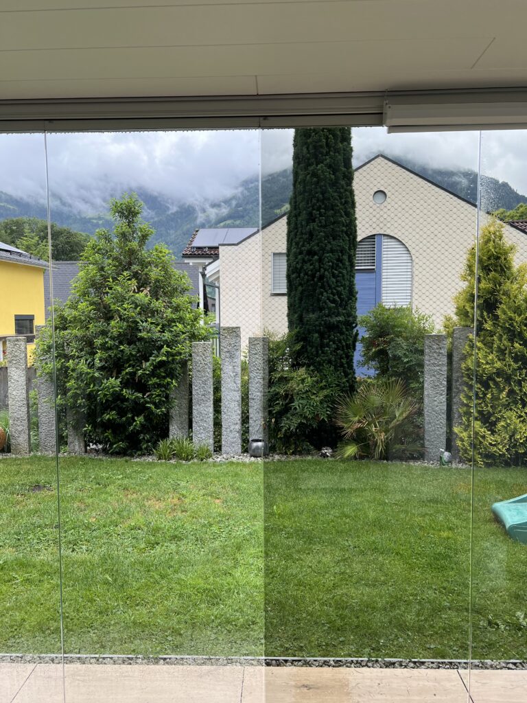 Fensterscheibe mit einer Sonnenschutzfolie und eine andere Fensterfront ohne Sonnenschutzfolie